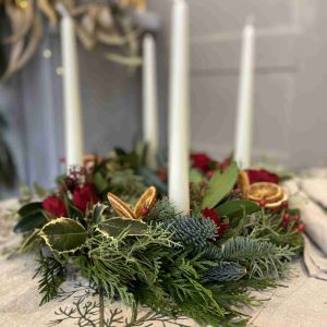 Corona de adviento con flor y verdes frescos